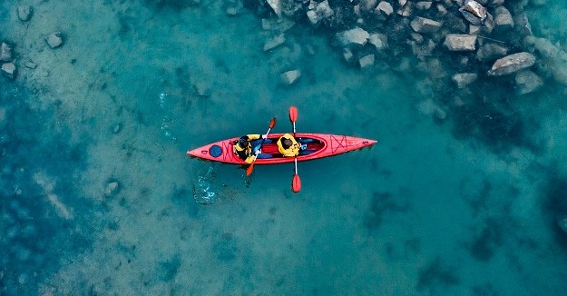 dwa atletyczny mezczyzna unosi sie na czerwonej lodzi w rzece